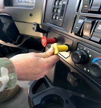 Push yellow knob to release parking brake or pull to apply parking brake.